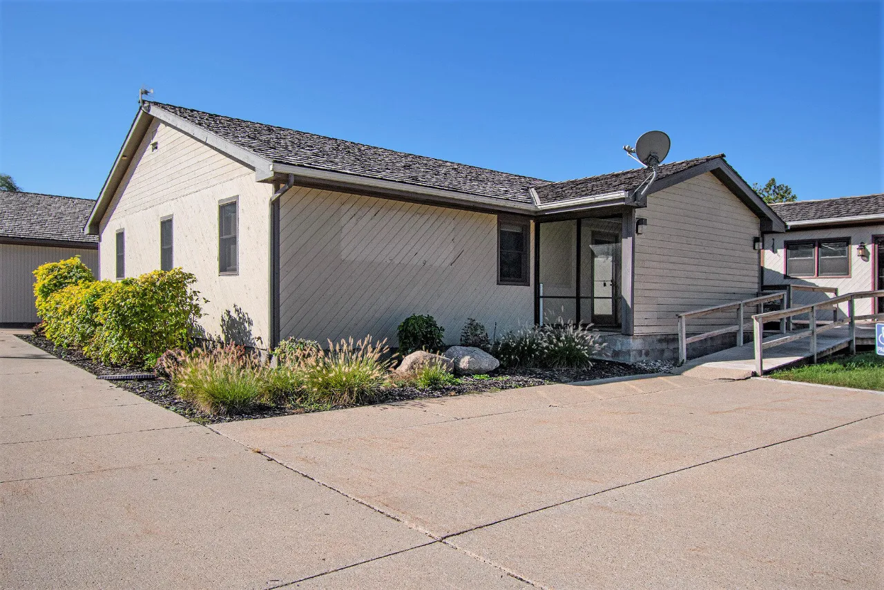 Low-rise building with a screened entrance, accessible ramp, and landscaped frontage.